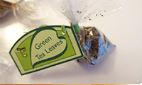 Steamy Leaf tea bag lables, and packaging shaped like a teapot, with colored stickers on the top to indicate the flavors inside.
